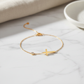 Gold cross bracelet flatlay